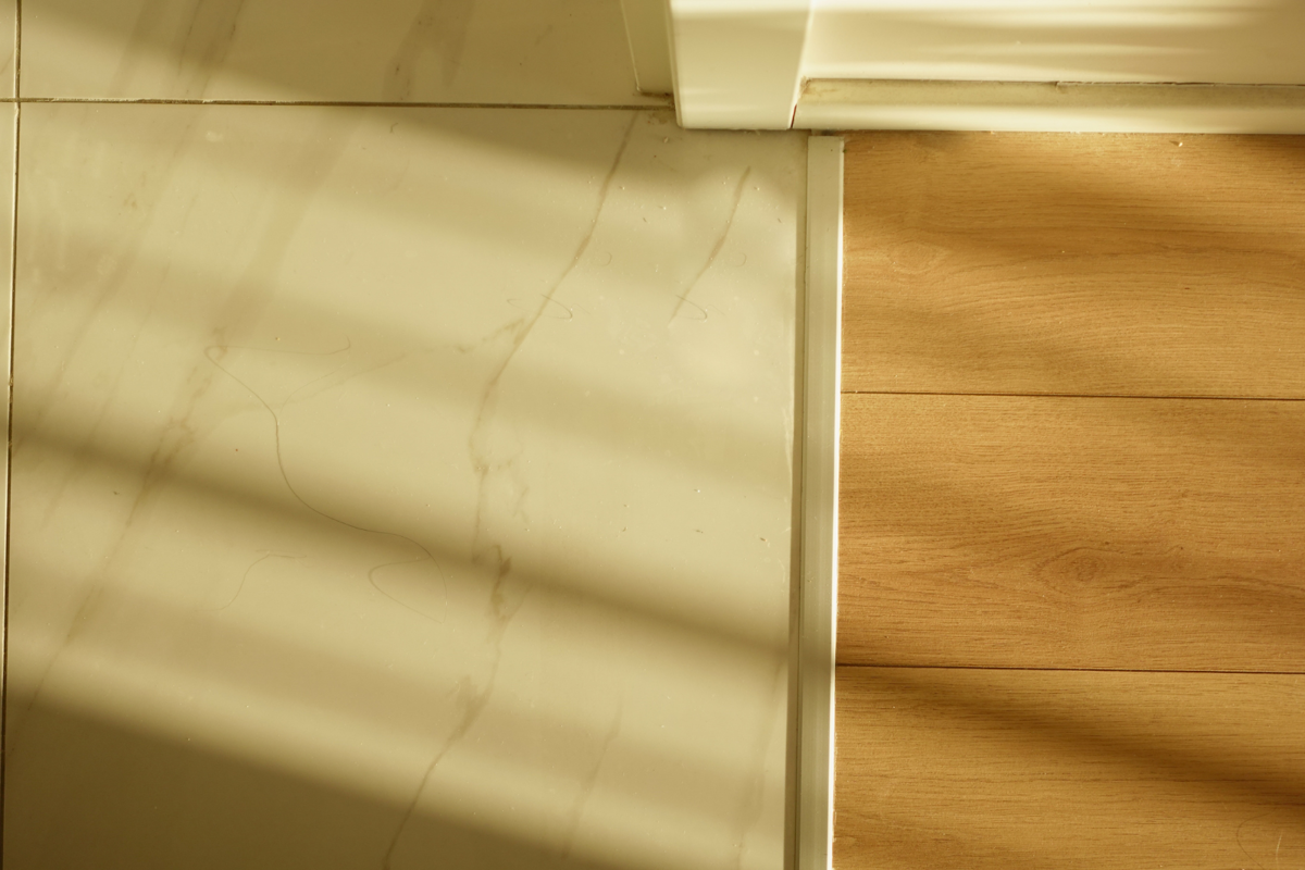 Overgang tussen parketvloer en tegelvloer Overgang tussen parketvloer en tegelvloer in natuurlijk licht